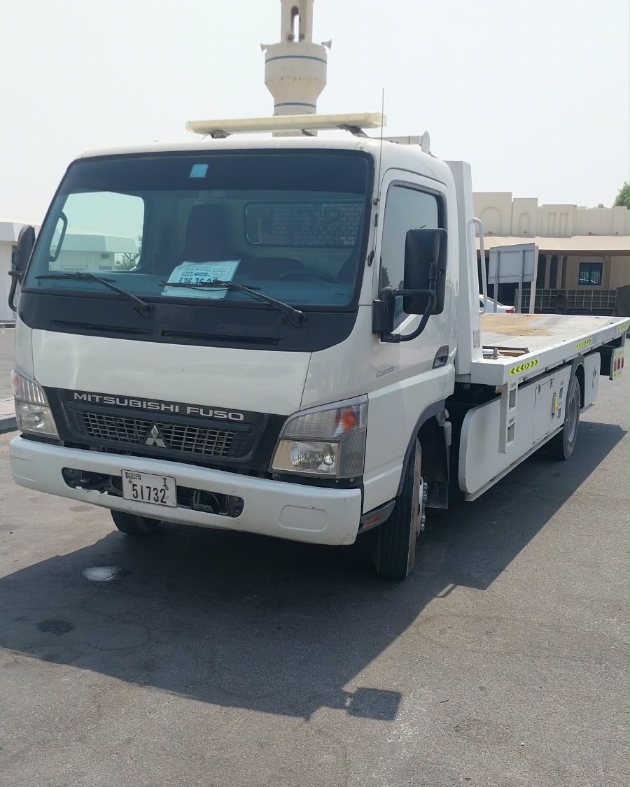 Front of Tanveer Recovery’s Mitsubishi Fuso flatbed truck, ready for 24/7 car recovery in Ajman