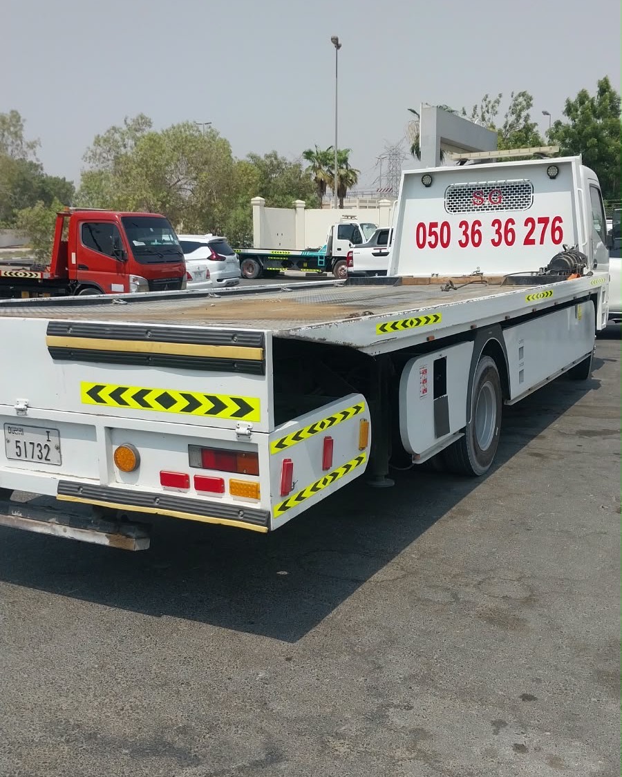 Tanveer Recovery flatbed tow truck in Ajman, with the phone number 050 36 36 276 on the headboard